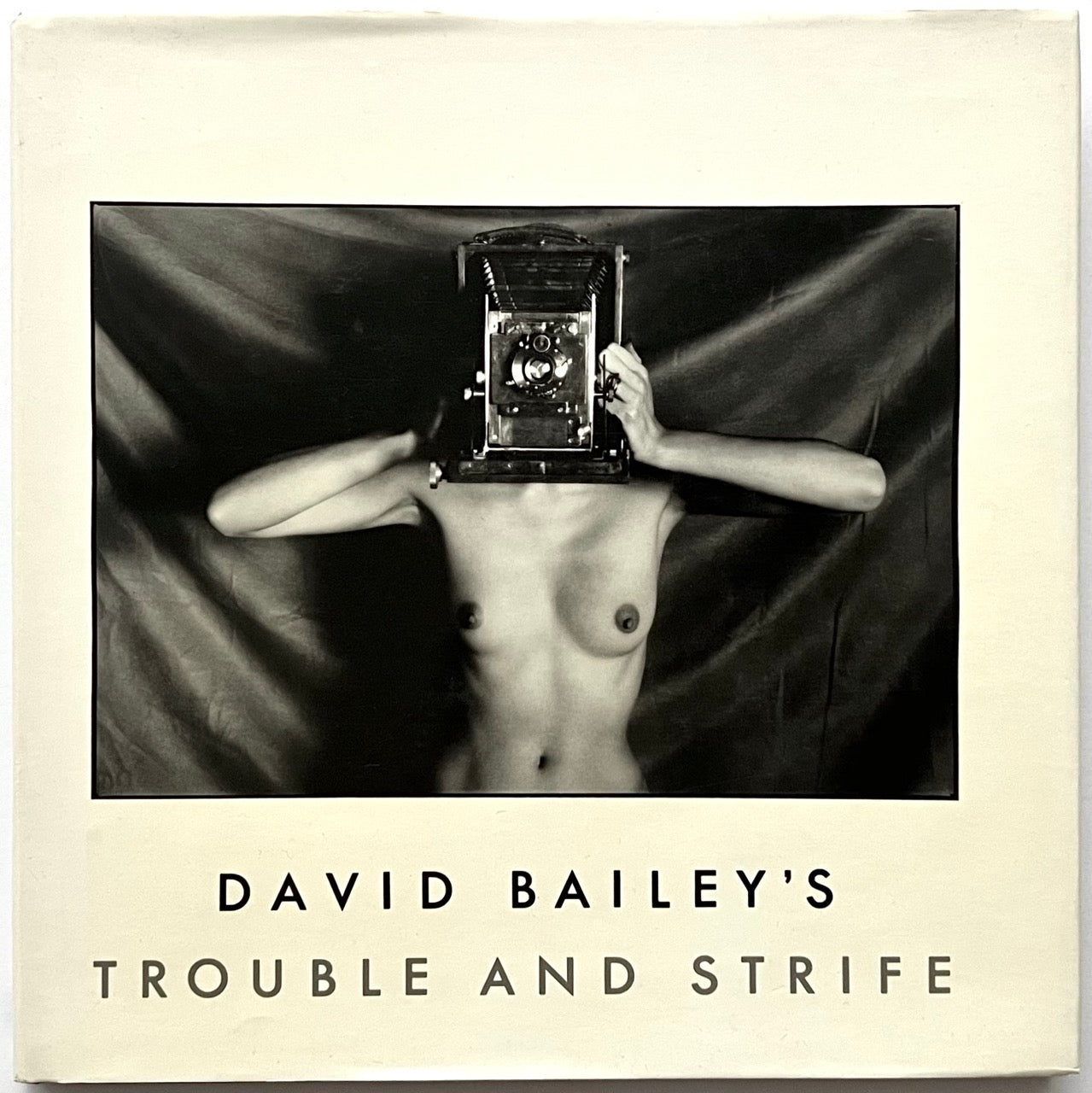 Book cover of 'David Bailey's Trouble and Strife' with a black and white photo of nude Marie Helvin holding a camera.