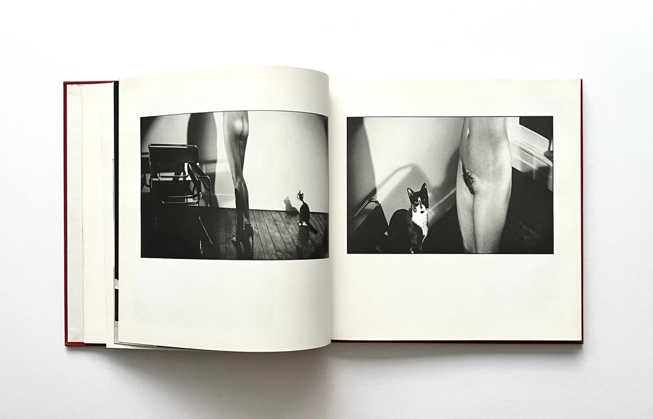 Open David Bailey's Trouble and Strife' book with black and white photographs of nude Marie Helvin with a cat.