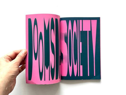 Doomsday Society Issue No. 01 – Interior spread with bold typographic design in pink and dark blue reading “Doomsday Society” across two pages.