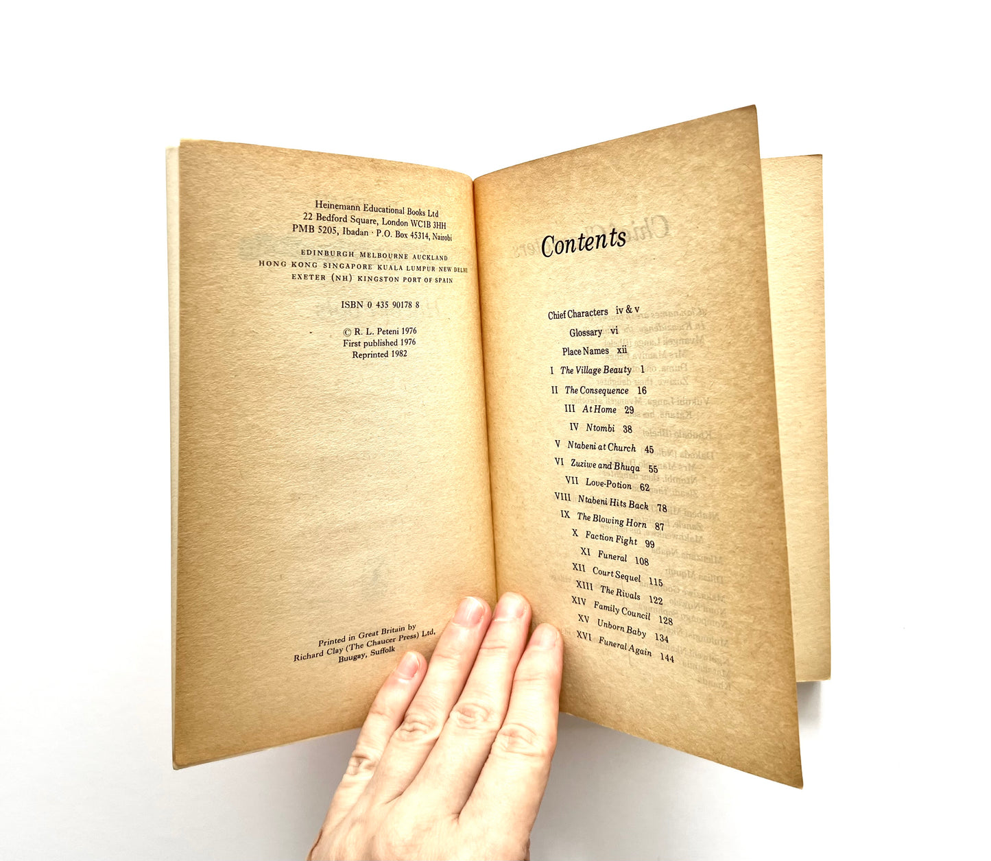 Open 'Hill of Fools' by R.L. Peteni book showing bibliographical information and contents, with a hand on a white background