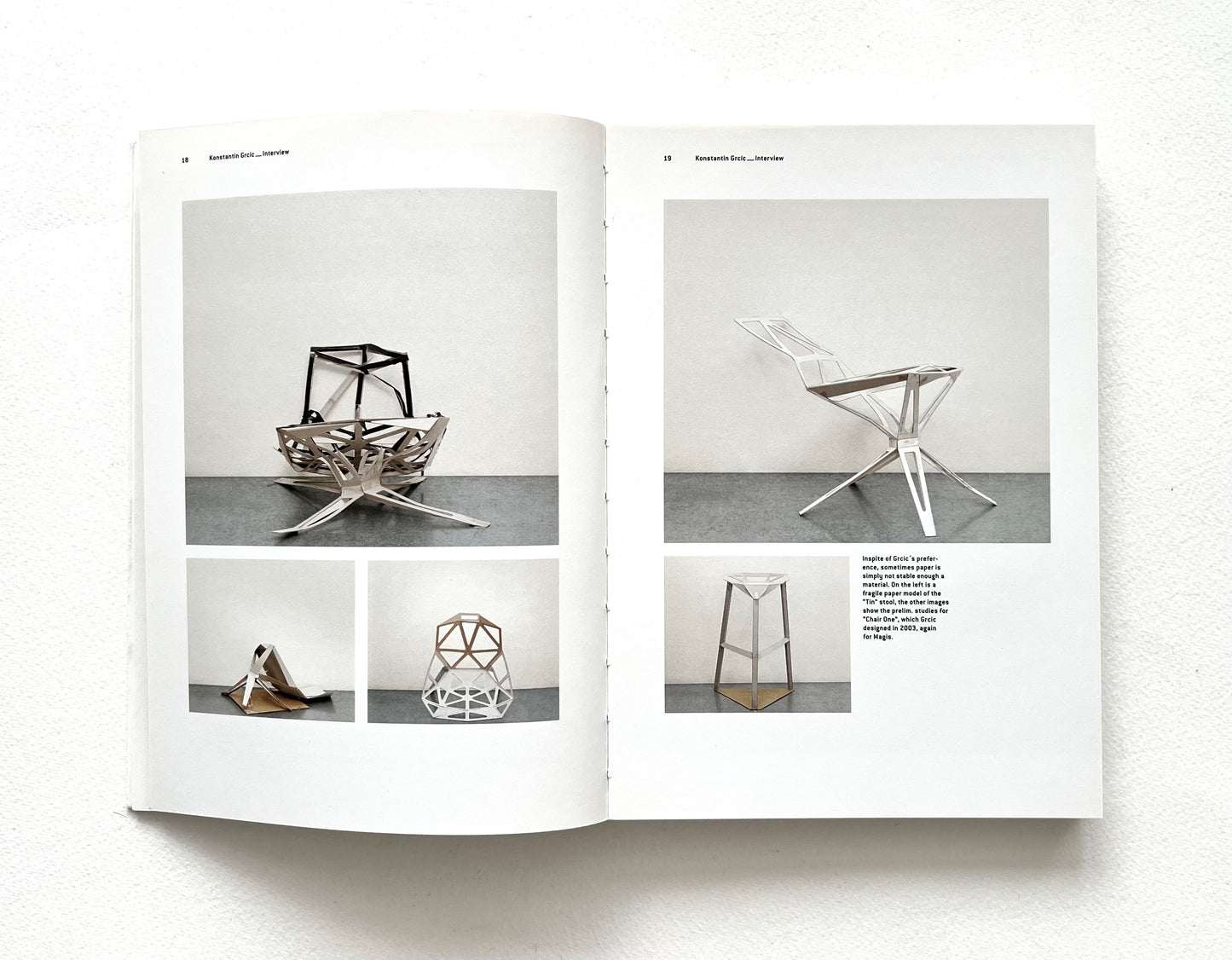Open book showing images of geometric chairs on a white background