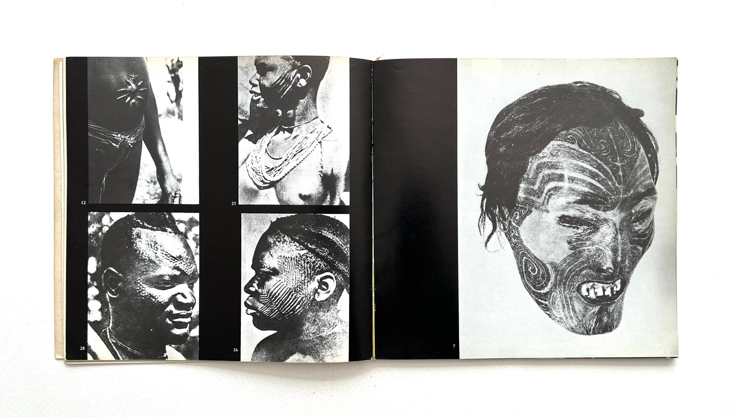 Open book showing black and white images of faces with tattoos