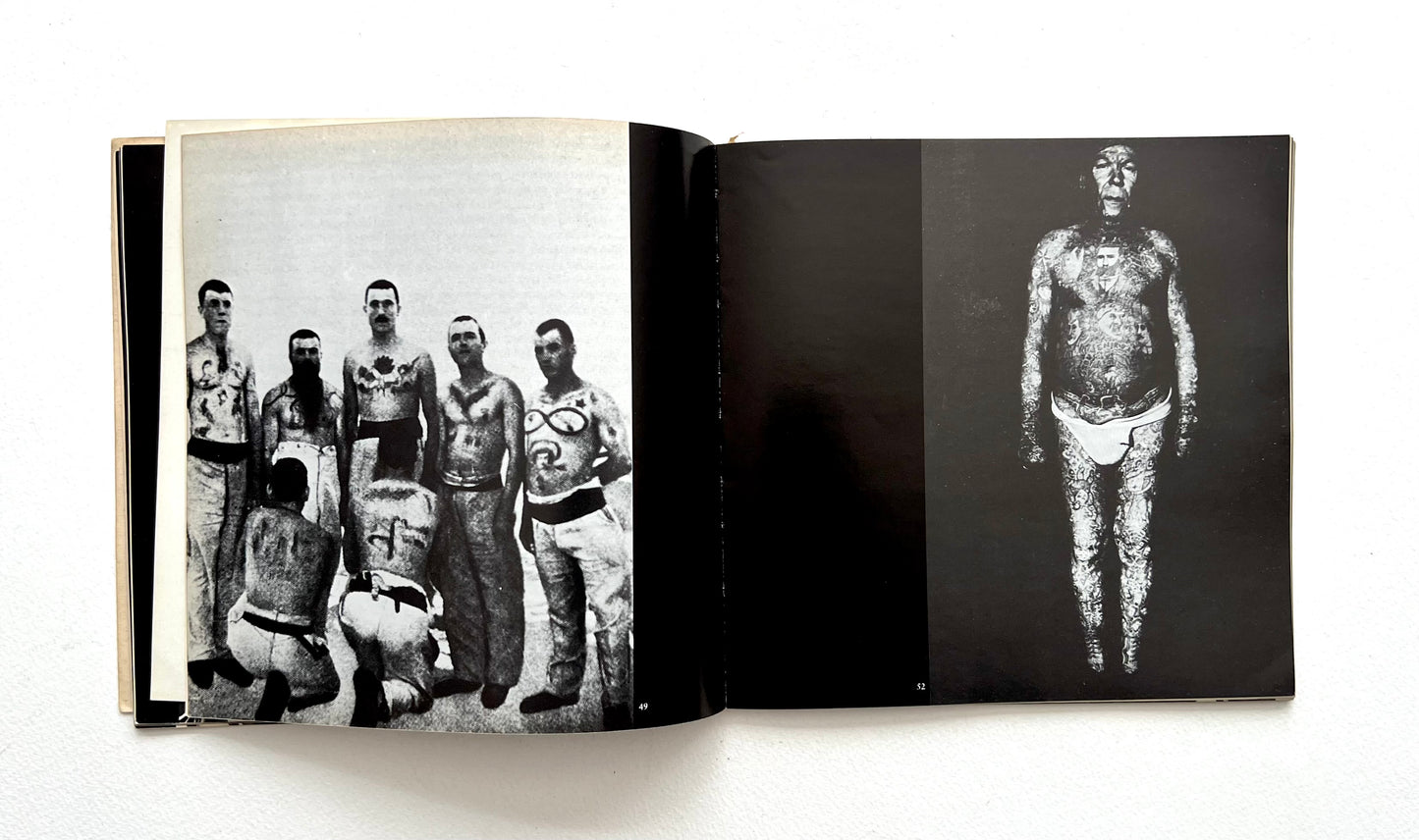 Open book showing black and white photographs of tattooed people on a white background