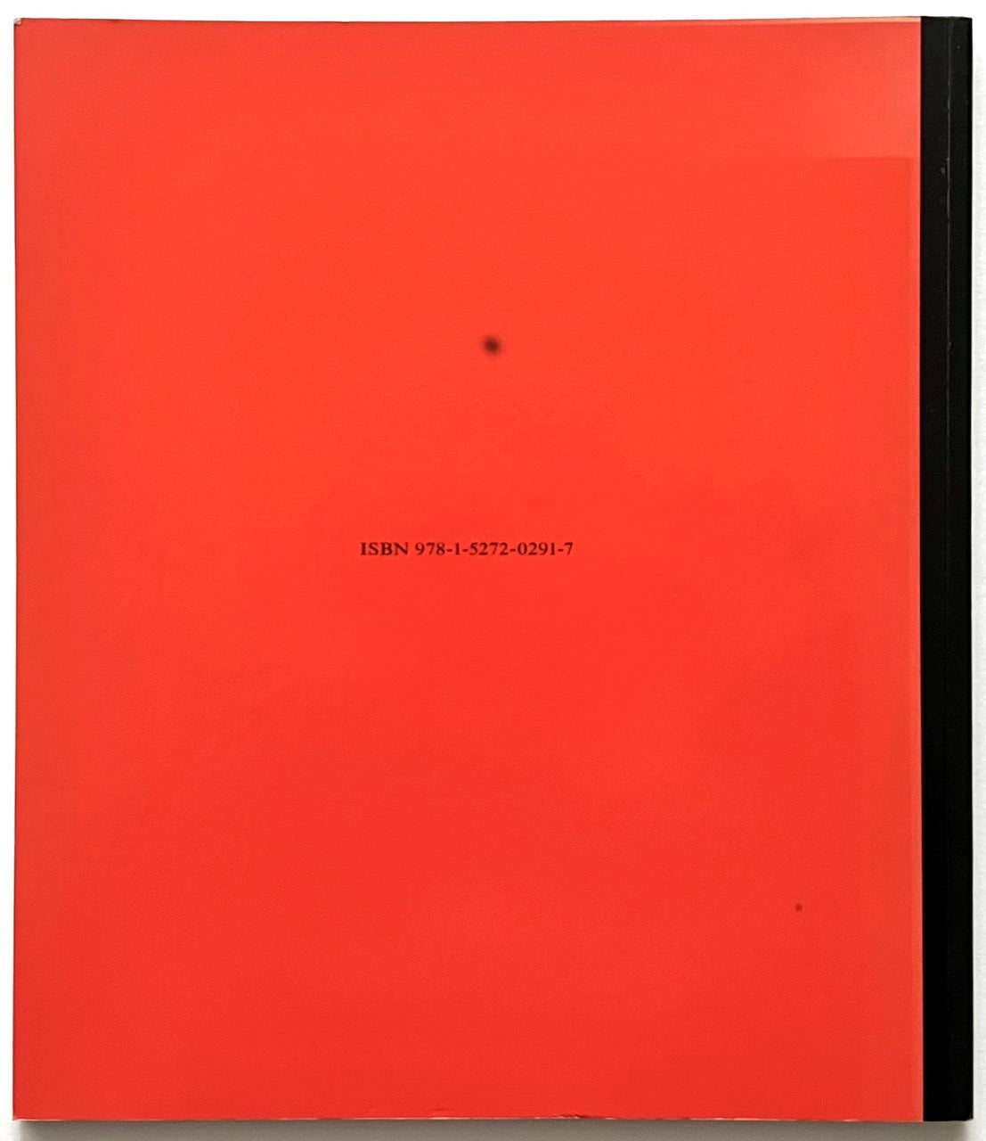 Red rear book cover with black text and a small black dot.