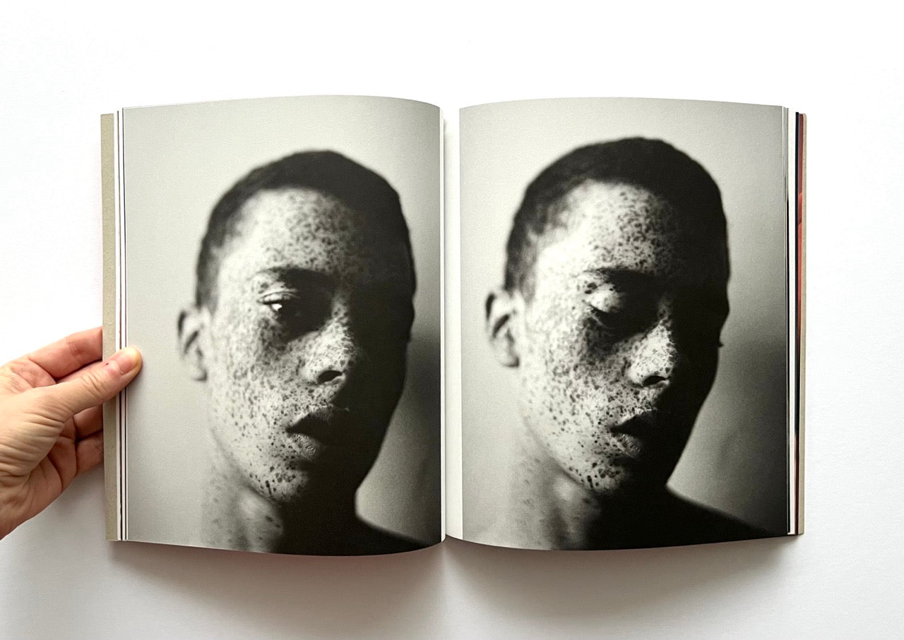Open book - 'Port Yarin' by Jeff Hahn - showing a black and white photo of a frackled man's face on each page.