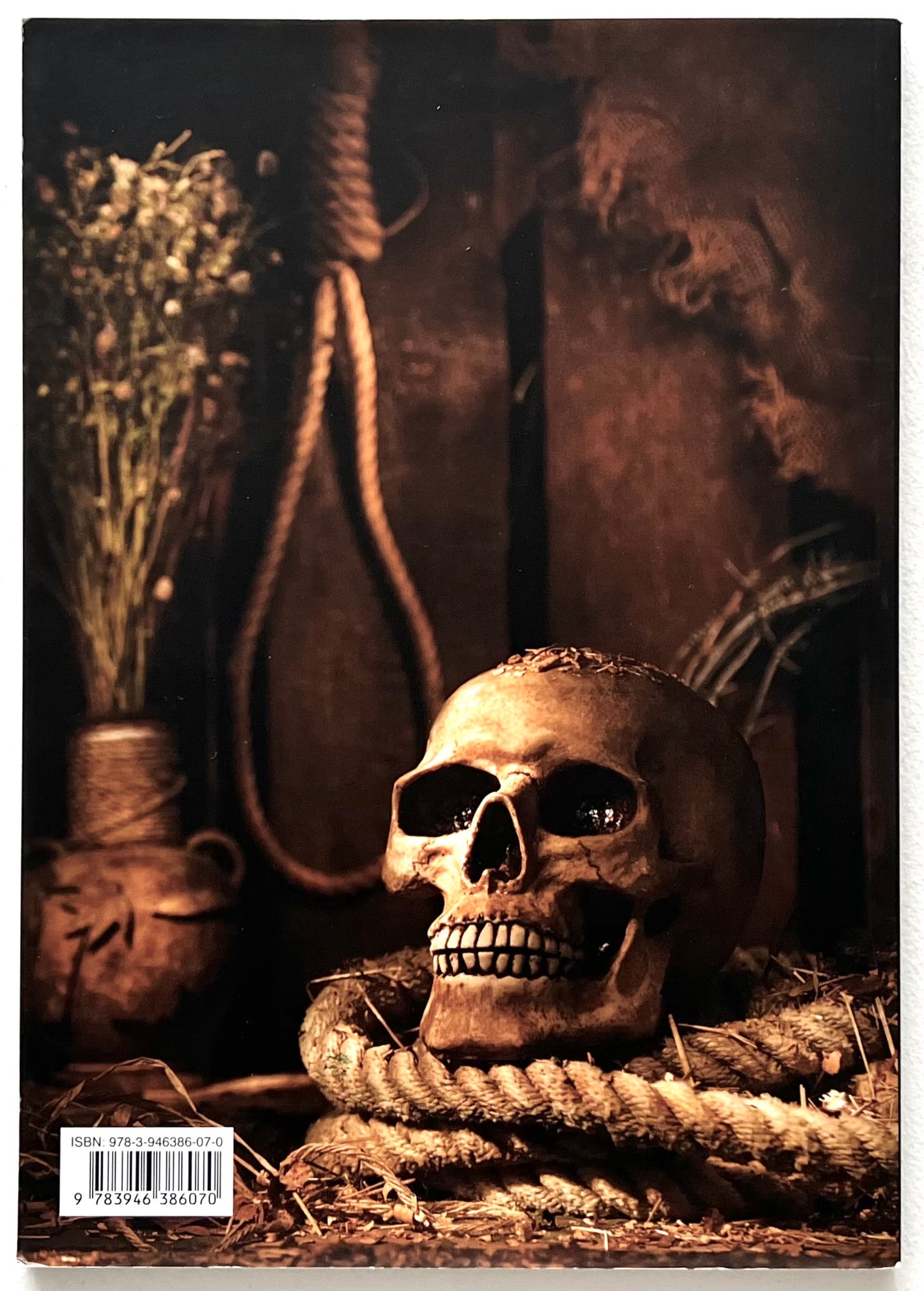 Rear cover of the 'Skulls & Bones' book, showing a skull with rope, vase of flowers, and dark background
