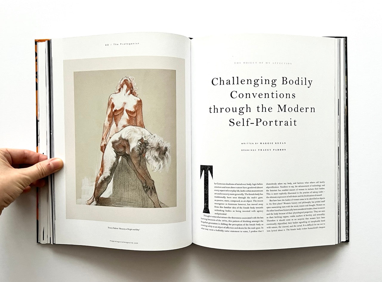 Open 'The Protagonist Magazine' issue 1, with a nude self-portrait on one page and text on the other, held by a hand.