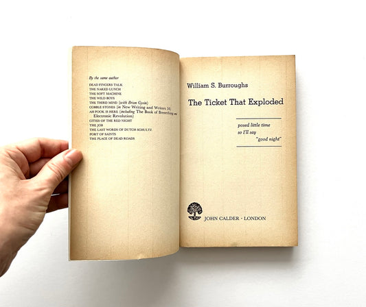 Open book - 'The Ticket That Exploded' by William S. Burroughs - held by a hand.