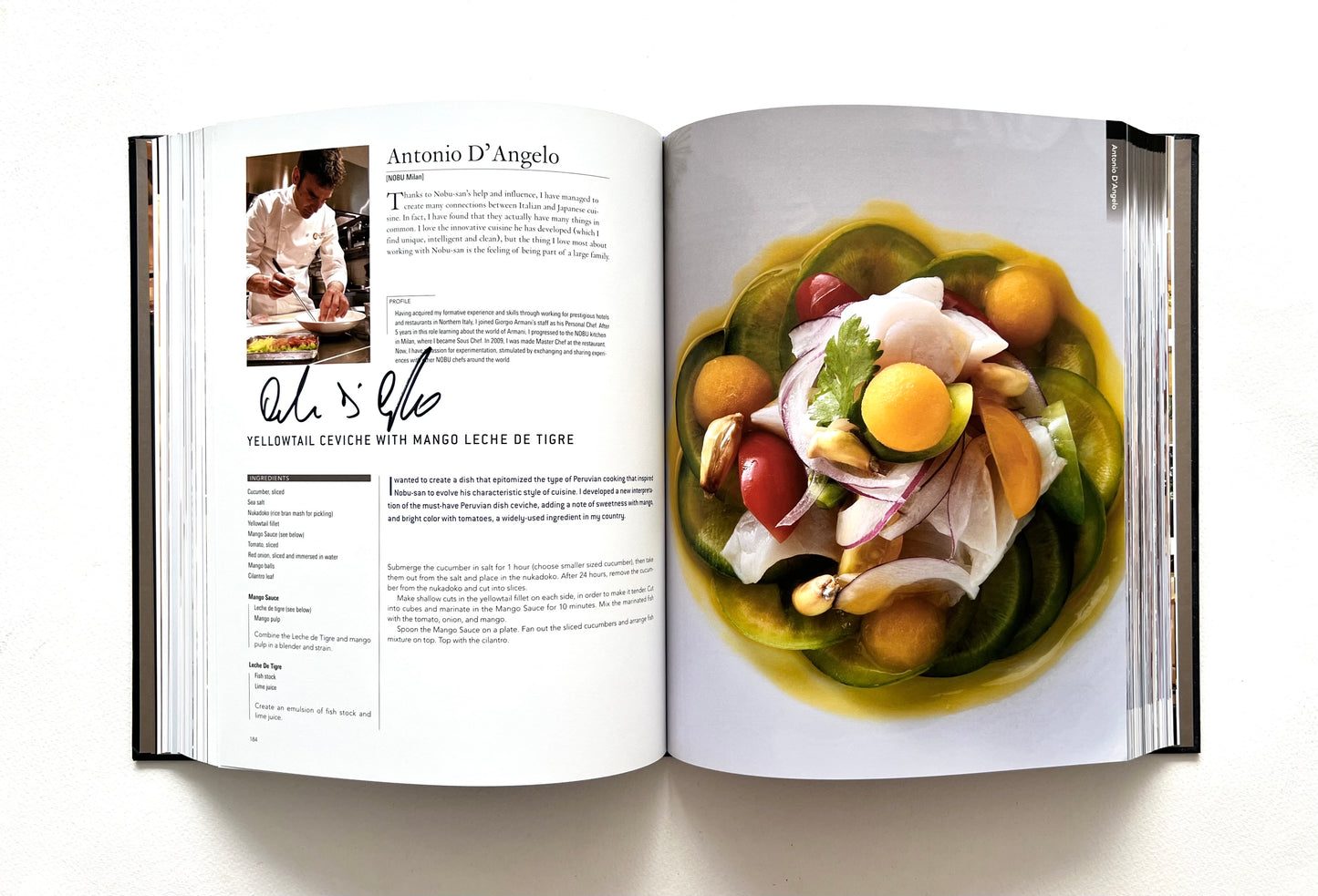 Open "World of Nobu" cookbook showing a page with a recipe and a colorful YELLOWTAIL CEVICHE WITH MANGO LECHE DE TIGRE dish - signed by chef Antonio D'Angelo.