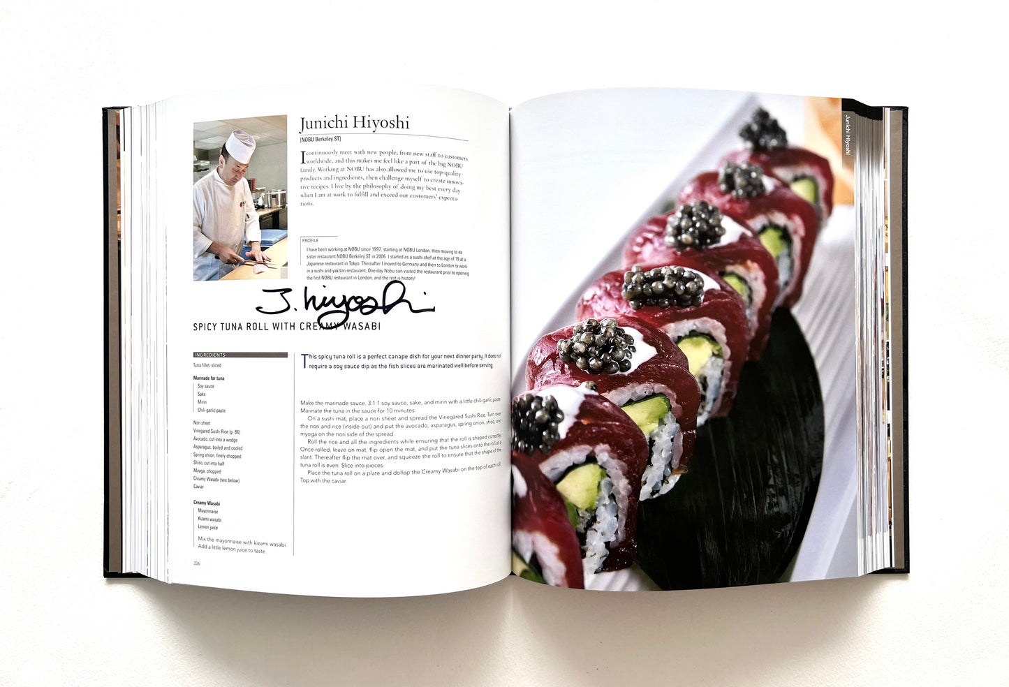 Open "World of Nobu" cookbook showing a recipe and a photo of a SPICY TUNA ROLL WITH CREAMY WASABI - signed by chef Junichi Hiyoshi.