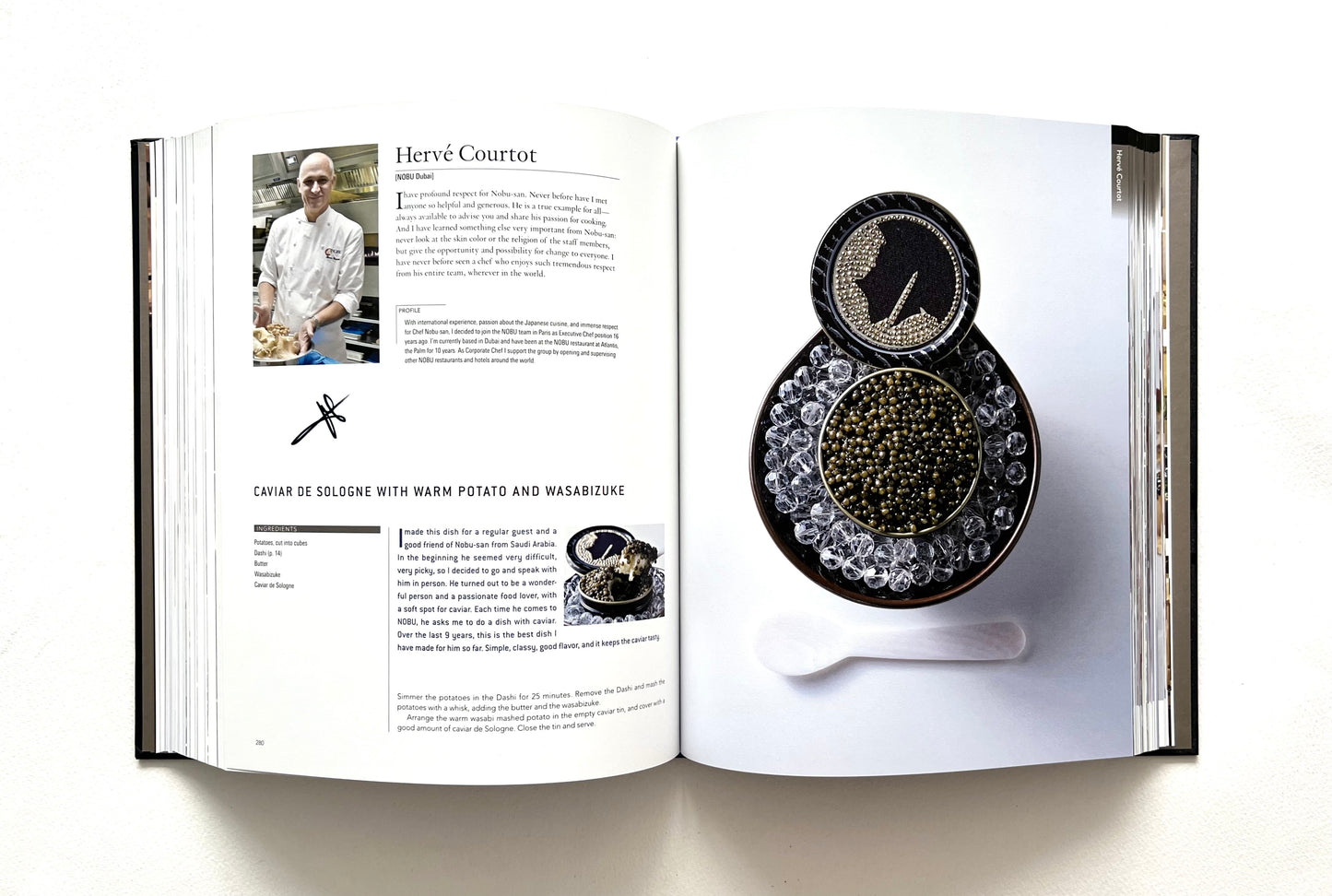 Open "World of Nobu" cookbook with a recipe and a photograph of a CAVIAR DE SOLOGNE WITH WARM POTATO AND WASABIZUKE dish - signed by chef Herve Courtot.