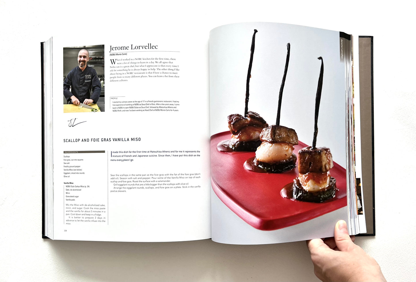 Open "World of Nobu" cookbook showing a recipe and a photo of a SCALLOP AND FOIE GRAS VANILLA MISO dish - signed by chef Jerome Lorvellec.