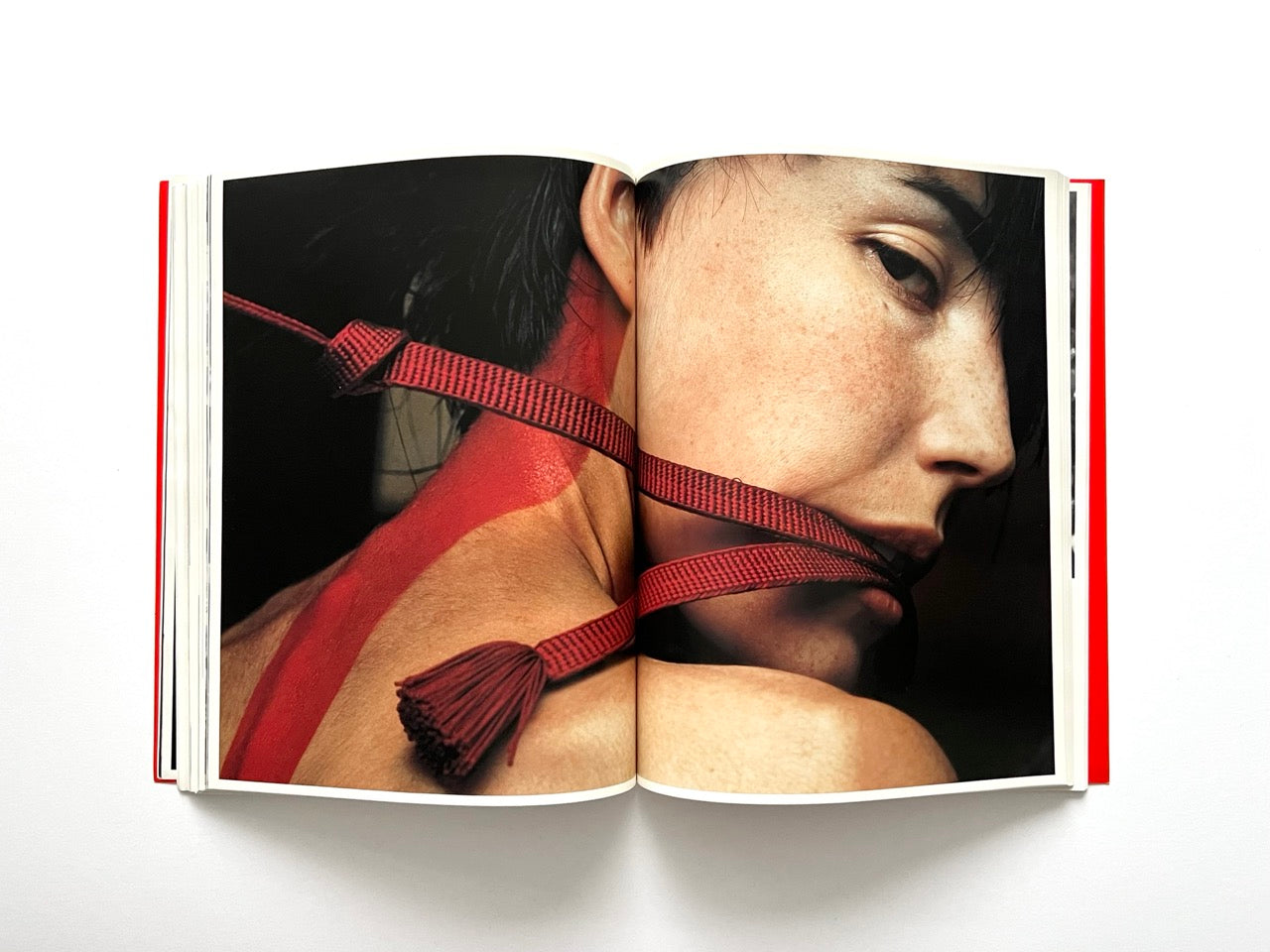 Interior spread of 10 Magazine Issue One featuring a close-up portrait of a model with a red strap across the neck