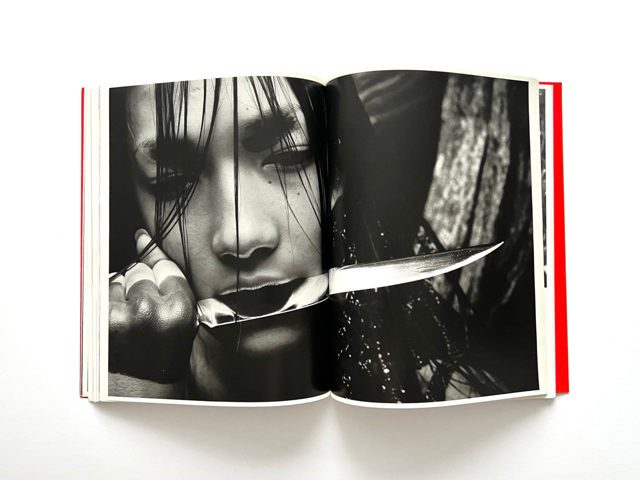 Interior spread of 10 Magazine Issue One showing a dramatic black and white portrait of a model holding a knife in her mouth