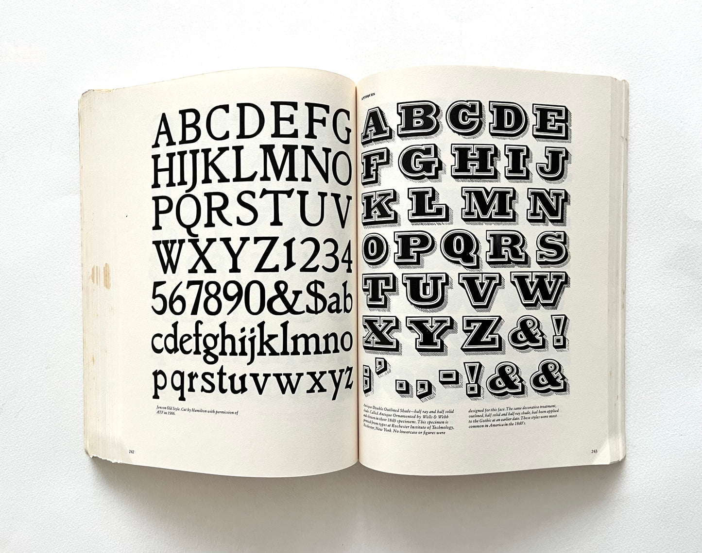 Open book displaying a typographic alphabet and numbers on a white background