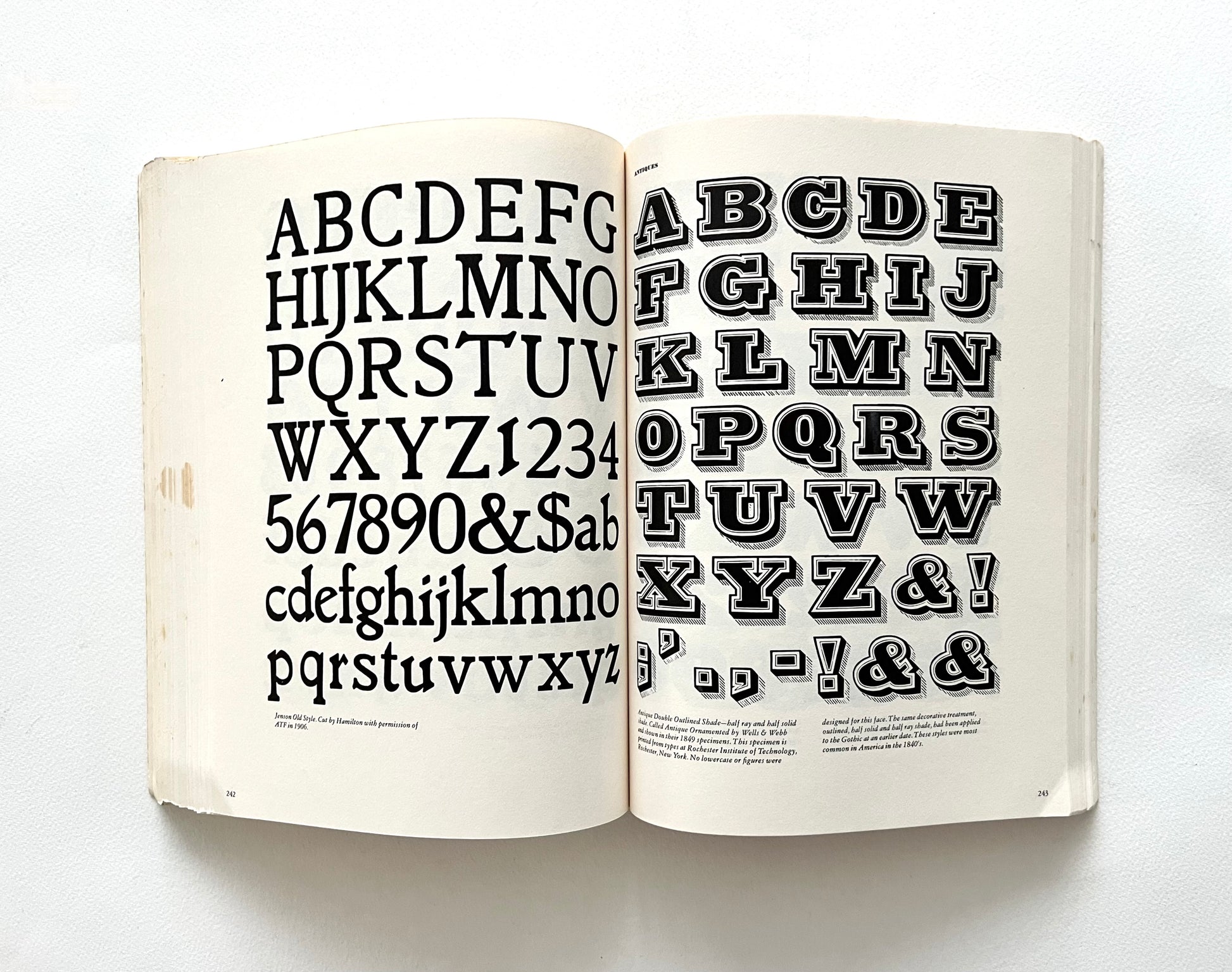 Open book displaying a typographic alphabet and numbers on a white background