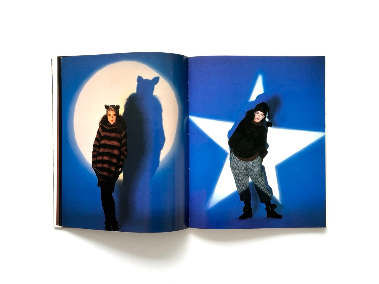 Interior spread from Atsuki Onishi's Knit Picture Book, published in 1989, featuring dramatic studio portraits of models wearing oversized knit garments against moon and star-shaped light projections.