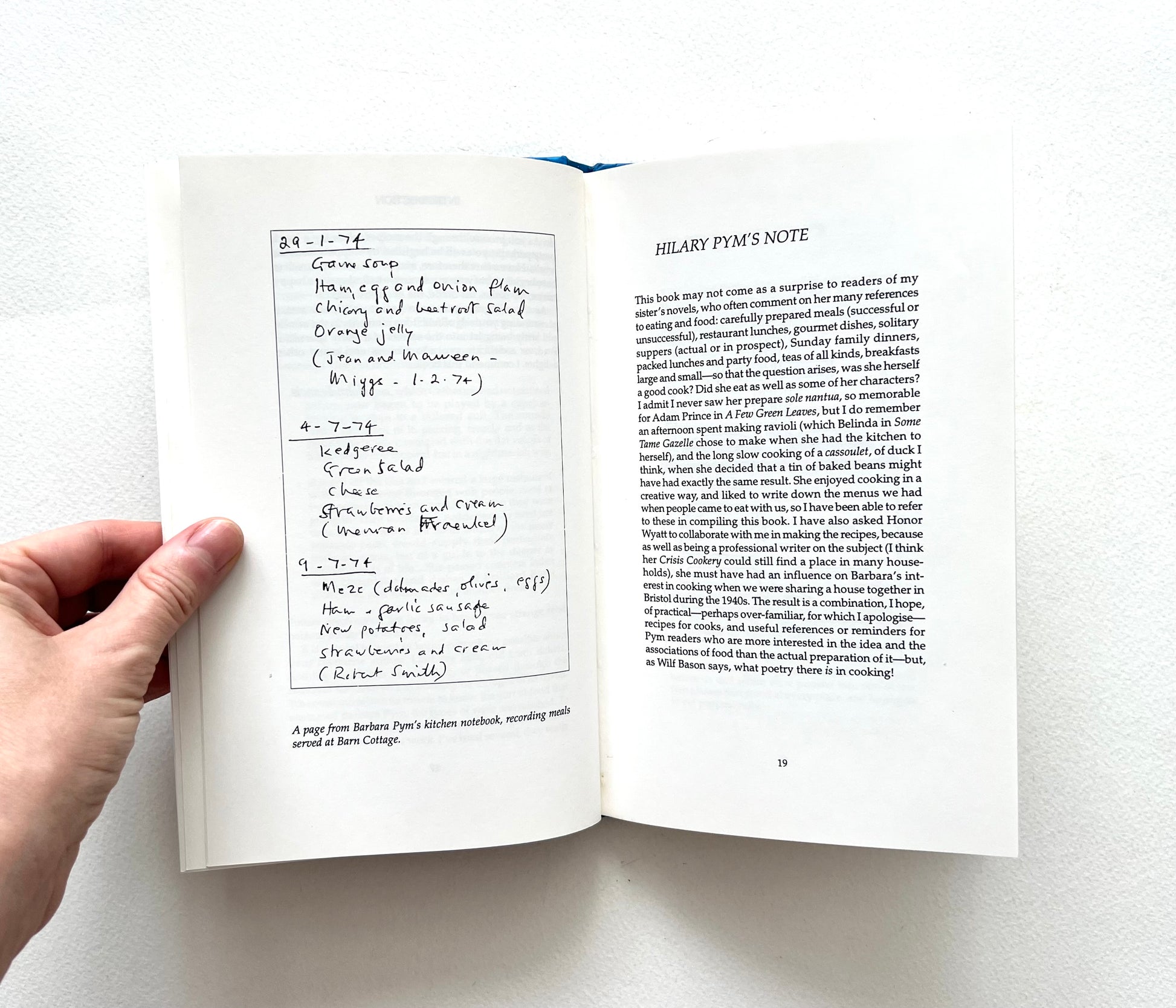 Open book showing a reproduction of a page from Barbara Pym's kitchen notebook on a white background
