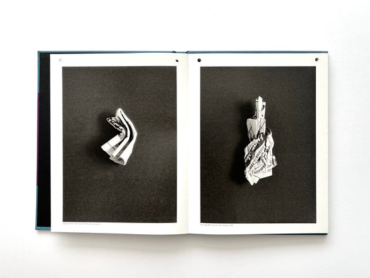 Interior spread from A Series of Disappointments (2008) by Stephen Gill, featuring two black-and-white photographs of folded and crumpled discarded betting slips against dark backgrounds.
