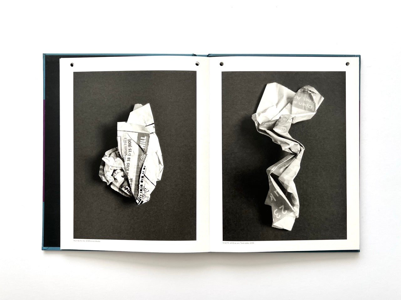 Interior spread from A Series of Disappointments (2008) by Stephen Gill, featuring two discarded betting slips folded and crushed into distinctive abstract forms and photographed in black and white.