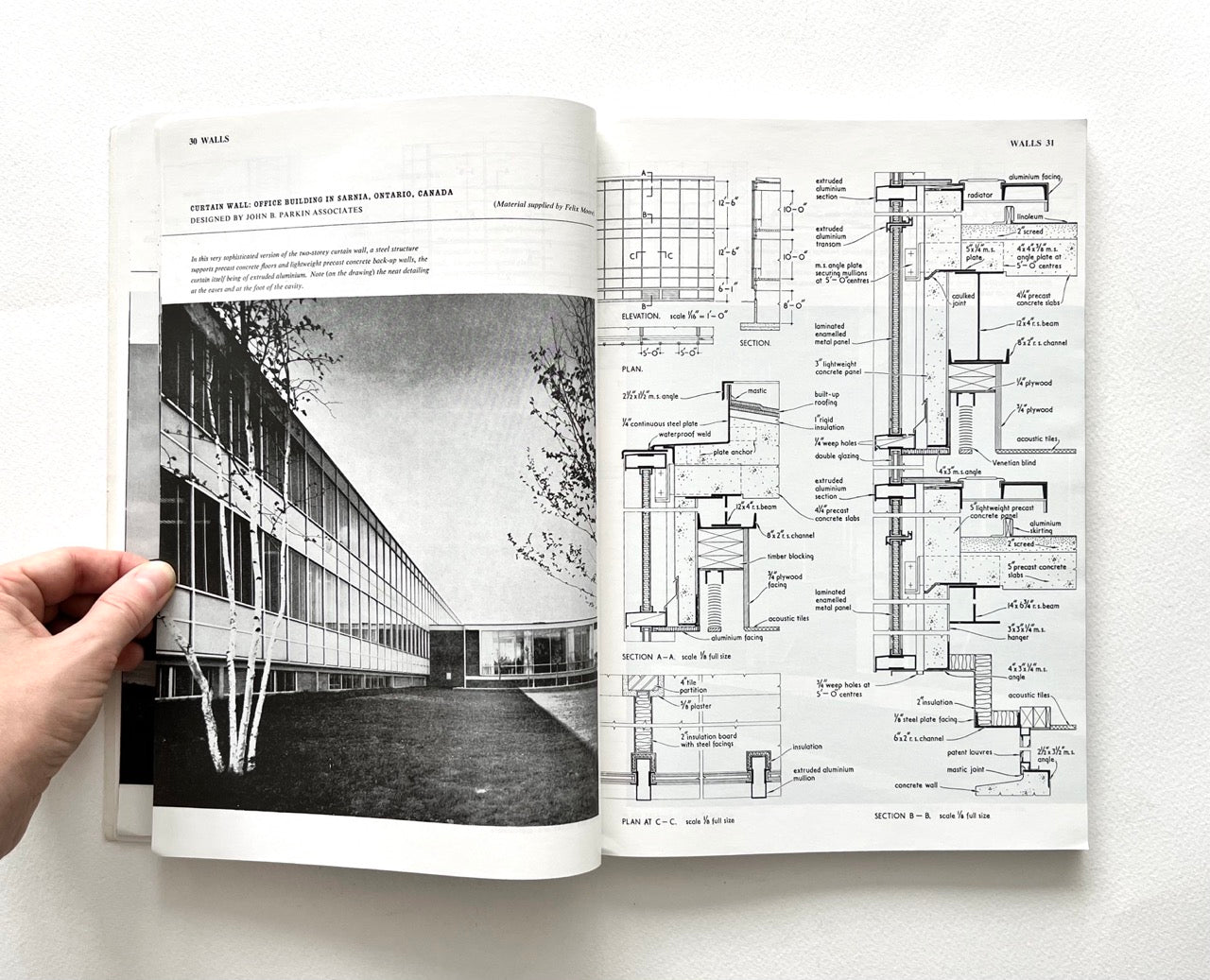 Open book - BEST OF ARCHITECTS’ WORKING DETAILS - VOLUME 1: EXTERNAL - showing b&w photograph of a modern building facade and an architectural drawing.