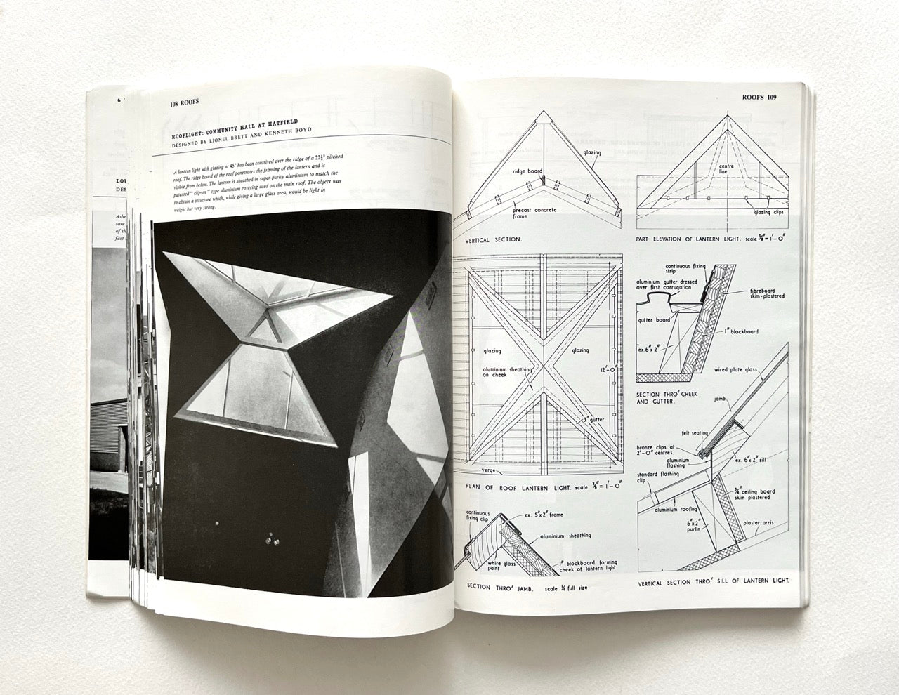 Open book - BEST OF ARCHITECTS’ WORKING DETAILS - VOLUME 1: EXTERNAL - showing b&w photograph of a modern geometric roof window and an architectural drawing.