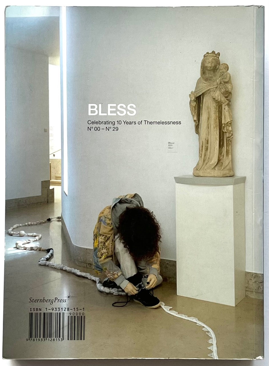 BLESS: Celebrating 10 Years of Themelessness, N° 00–N° 29 by Désirée Heiss and Ines Kaag, 2006. Back cover showing a person tying their shoe beside a religious sculpture in a gallery interior.