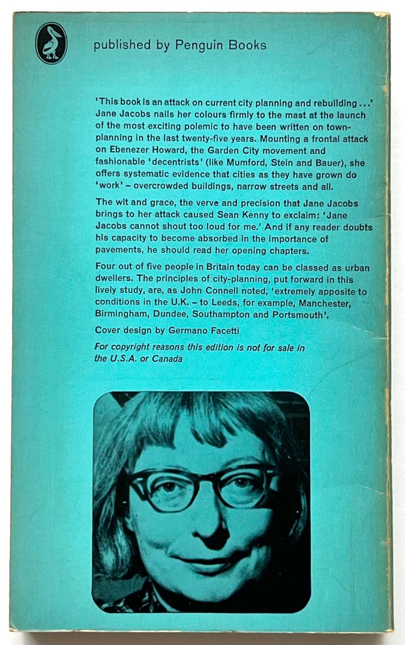 Back cover of a vintage Pelican paperback with turquoise background, featuring a block of white review text about urban planning and a black-and-white portrait photograph of a woman wearing glasses at the bottom, with visible edge wear.