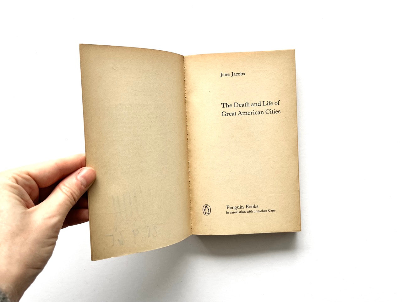 Title page spread of The Death and Life of Great American Cities by Jane Jacobs, showing yellowed pages, minimal serif typography, and Penguin Books imprint on the right-hand page.