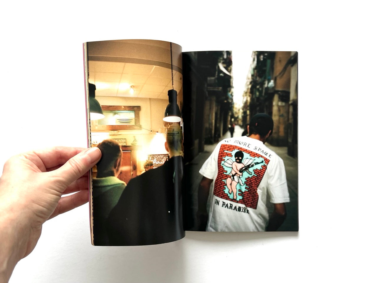 Doomsday Society Issue No. 01 – Interior spread showing candid bar interior scene alongside a street photograph of a figure wearing a graphic T-shirt reading “No More Space in Paradise”.