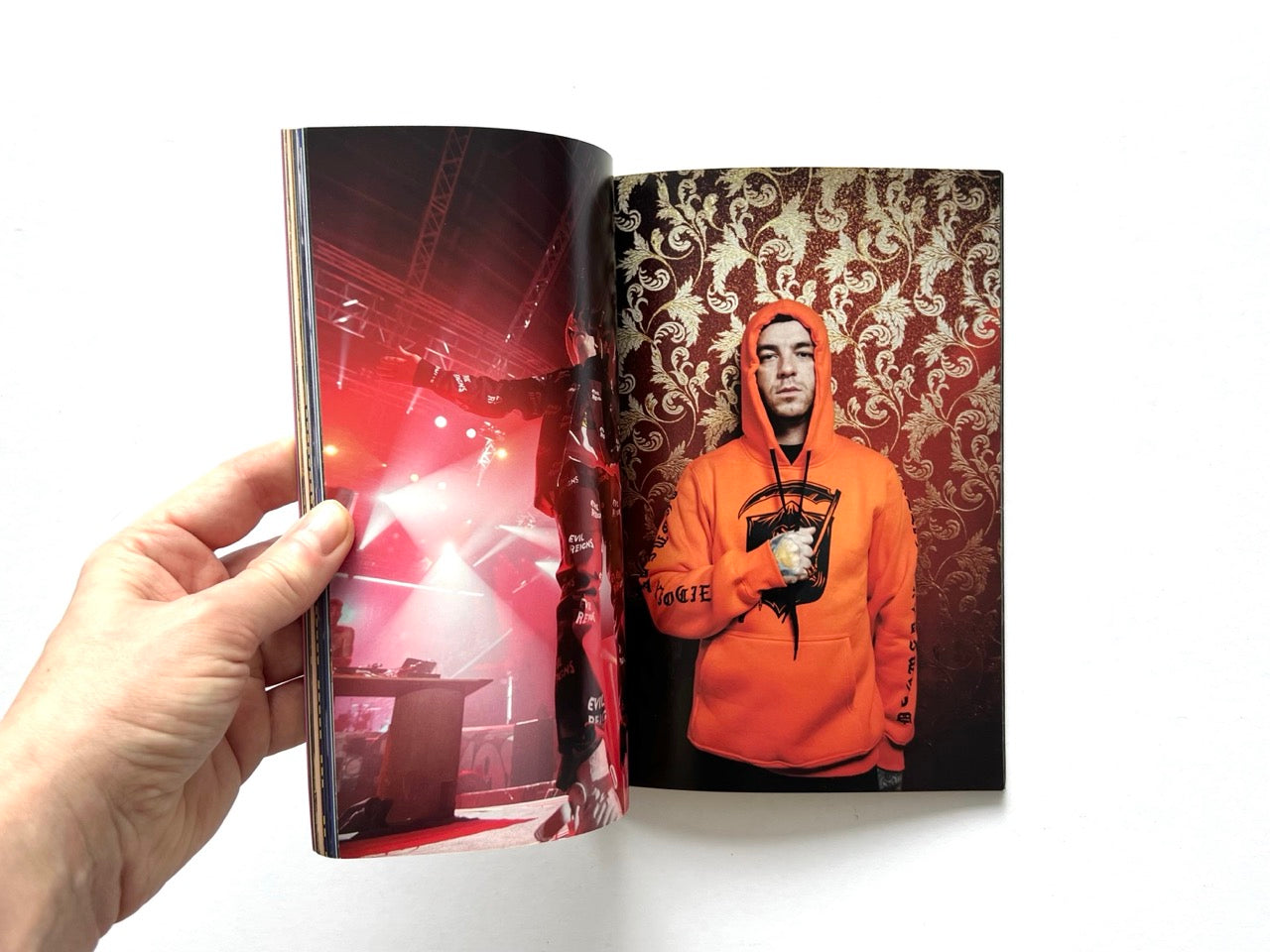 Doomsday Society Issue No. 01 – Interior spread showing performer on stage with red lighting and portrait of a model in orange hoodie against patterned wallpaper.