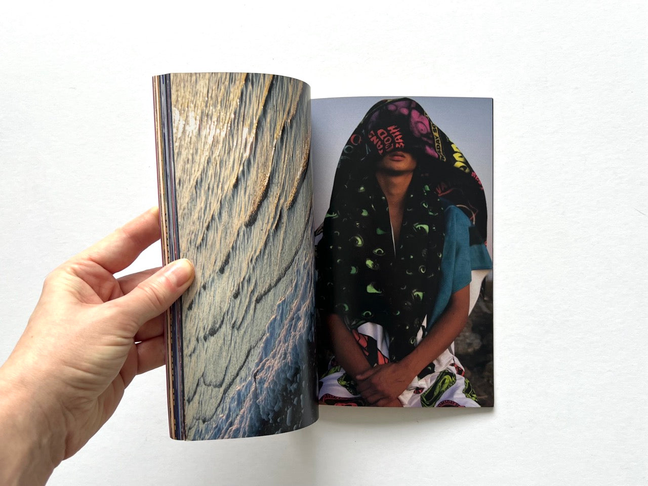 Doomsday Society Issue No. 01 – Interior spread with abstract textured surface photograph paired with portrait of a model draped in graphic printed fabric covering the face.
