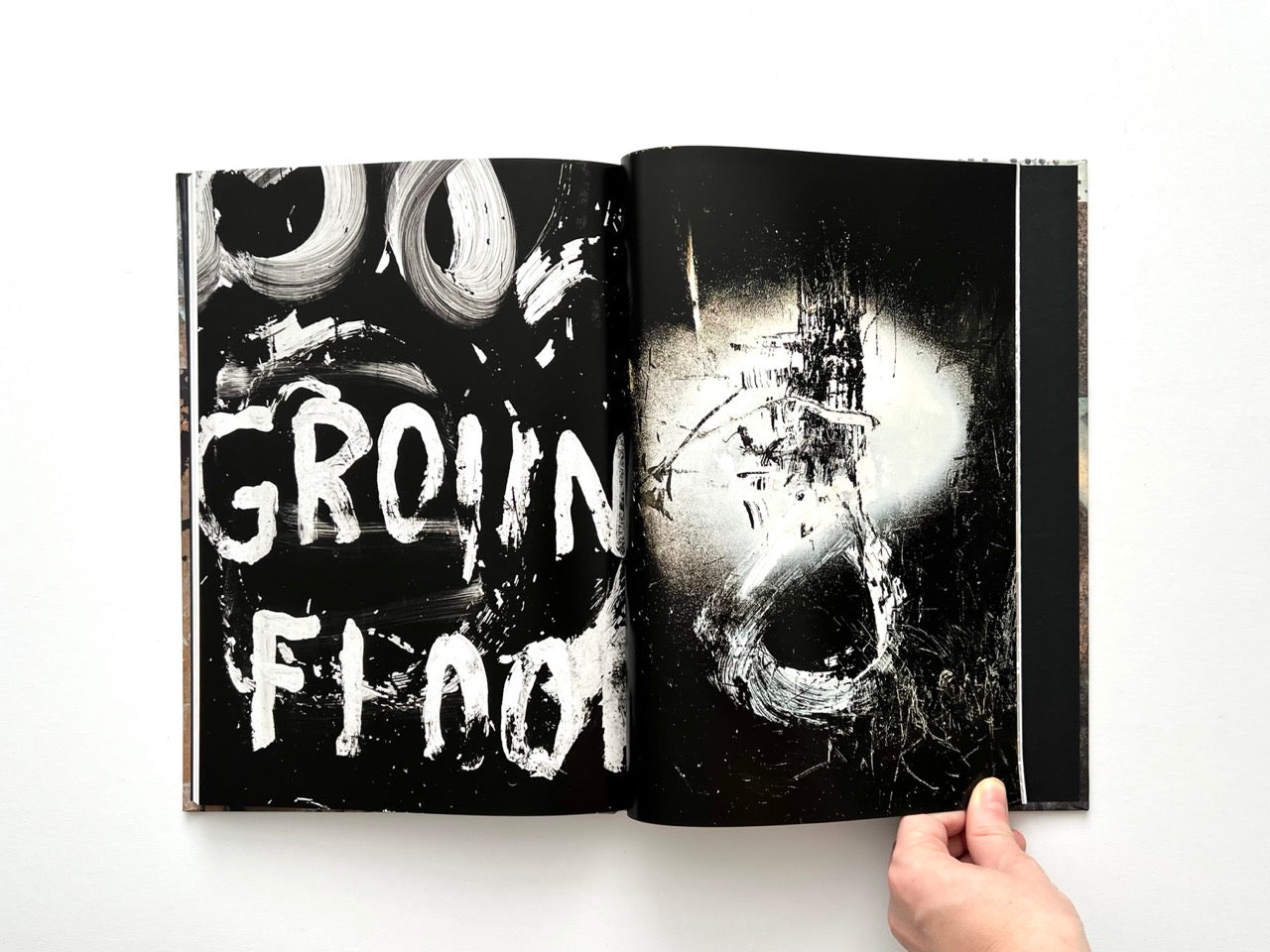 Interior spread from Dubious Splendor: Graphic Works by Rob Sanders 2023–2024 with bold black spreads and expressive white brush lettering