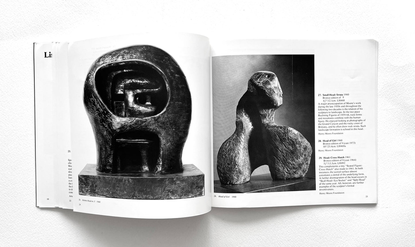 Open book showing black and white photographs of Henry Moore's sculptures on a white background