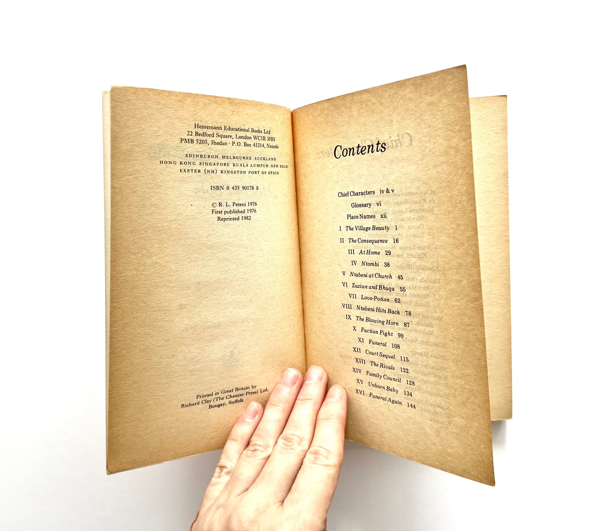 Open 'Hill of Fools' by R.L. Peteni book showing bibliographical information and contents, with a hand on a white background