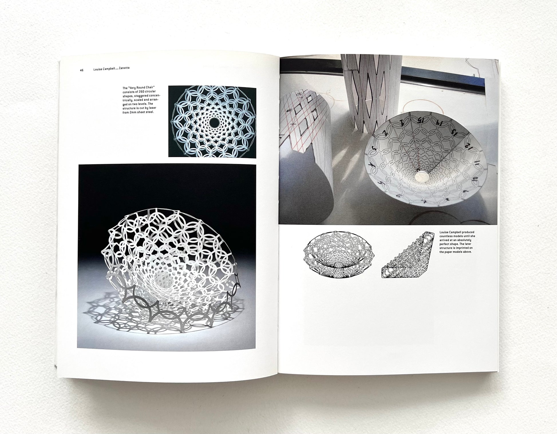 Open book showing images of a geometric wire sculpture with text on a white background