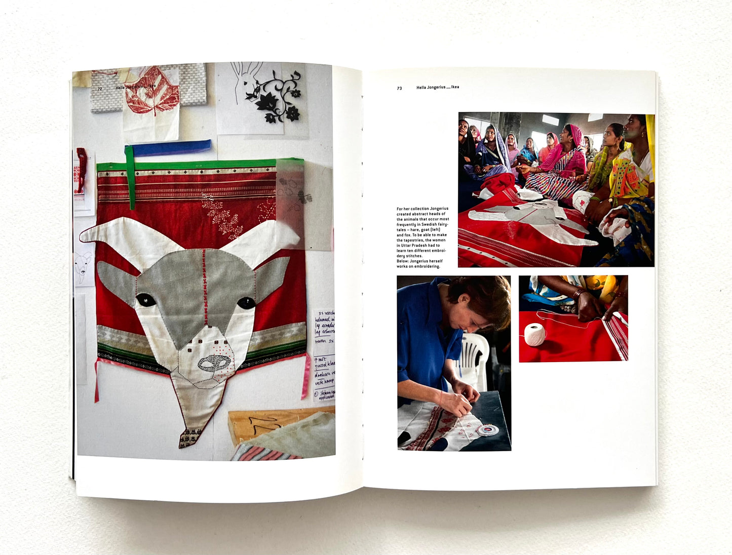 Open book showing a fabric art piece with a goat design and people working on fabric in a sewing room.