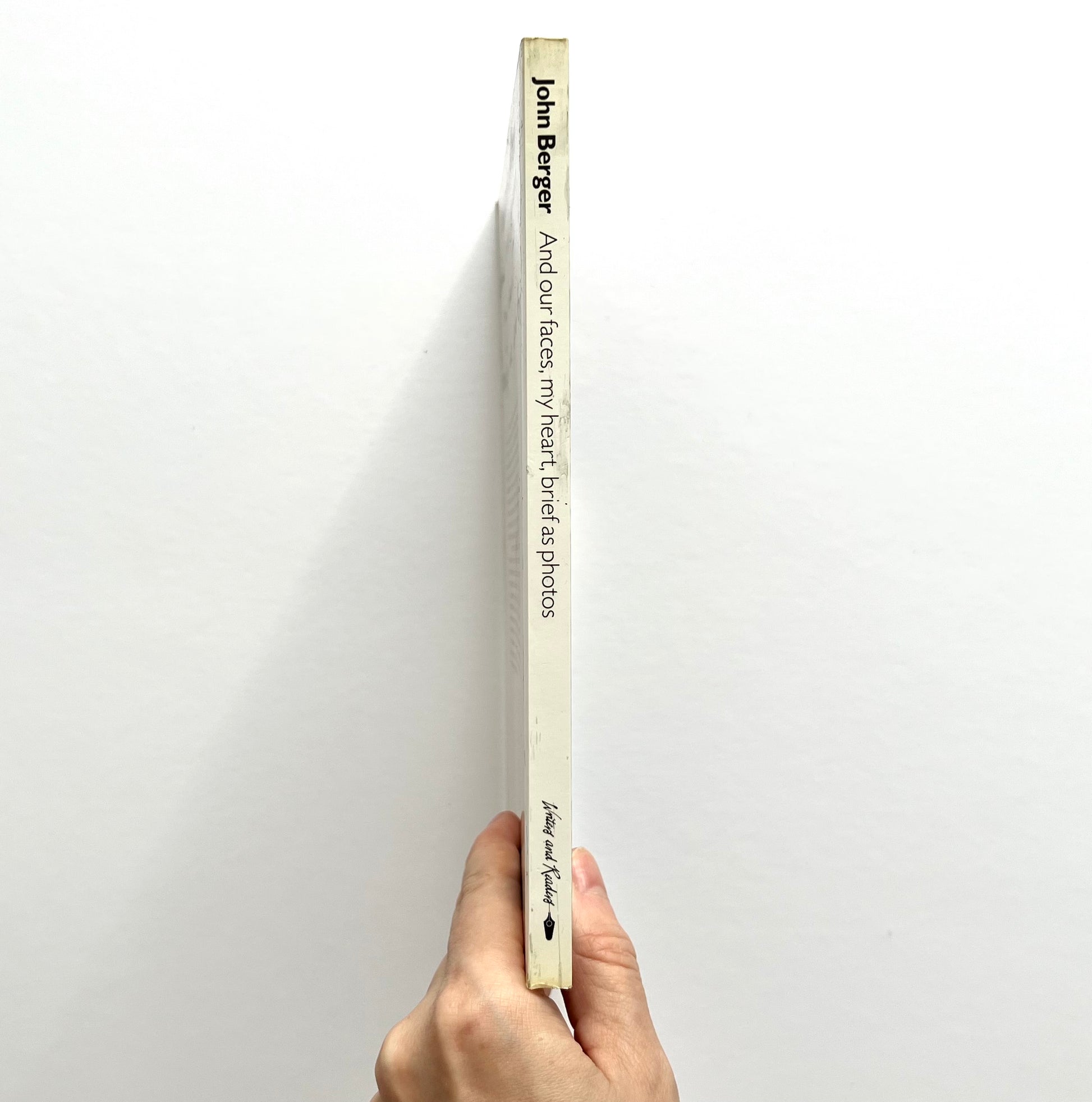 Book titled 'And Our Faces My Heart Berthel Airphotos' by John Berger held against a white background