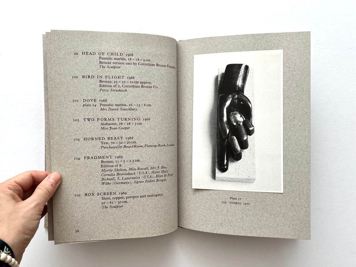 John Skelton: A Sculptor’s Work 1950–1975 (1977). Interior spread showing catalogue entries 99–105 on the left, including Head of Child, Bird in Flight, Dove, Two Forms Turning, Horned Beast, Fragment and Box Screen, with Plate 17 on the right featuring a black-and-white photograph of Symbol (1970).