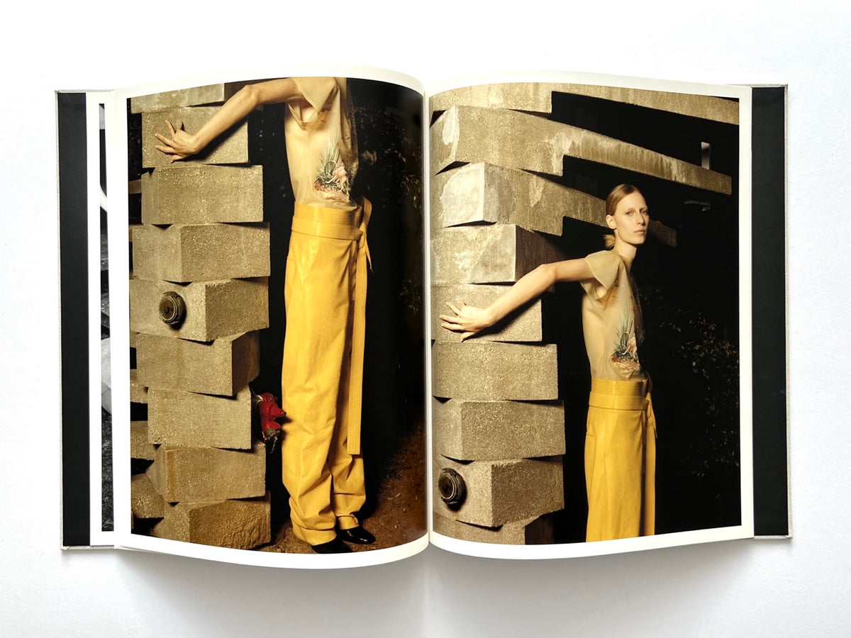 LOEWE Spring Summer 2015 Womenswear, photographed by Jamie Hawkesworth, 2015. Double-page colour fashion editorial showing Julia Nobis in a sheer printed top and yellow wide-leg trousers beside geometric concrete architecture.