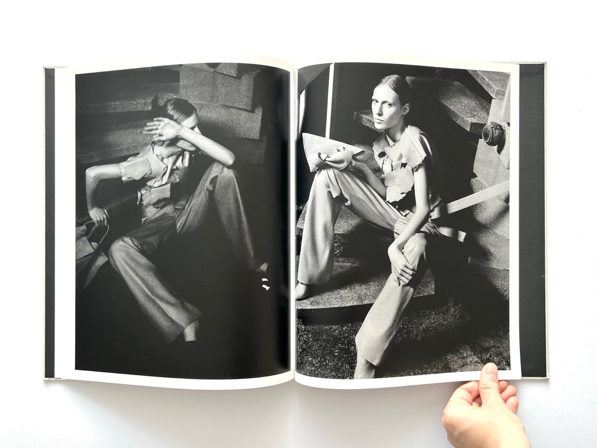 LOEWE Spring Summer 2015 Womenswear, photographed by Jamie Hawkesworth, 2015. Double-page black-and-white fashion editorial of Julia Nobis wearing sculptural layered garments and tailored trousers, seated among concrete structures.