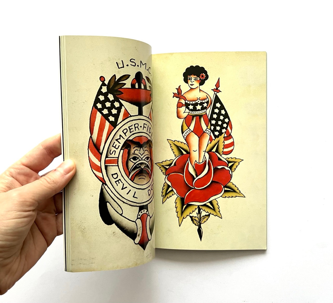 Open book displaying vintage-style tattoo designs on beige pages.