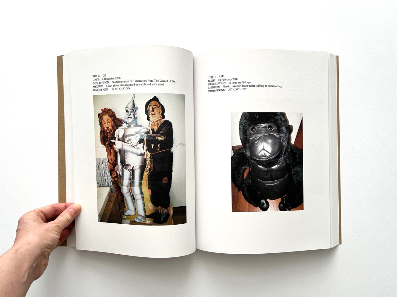 Lutz Bacher: Snow (2013), interior spread featuring “Oz” cut-out figures of Wizard of Oz characters and “Ape” black sculptural toy-like figure
