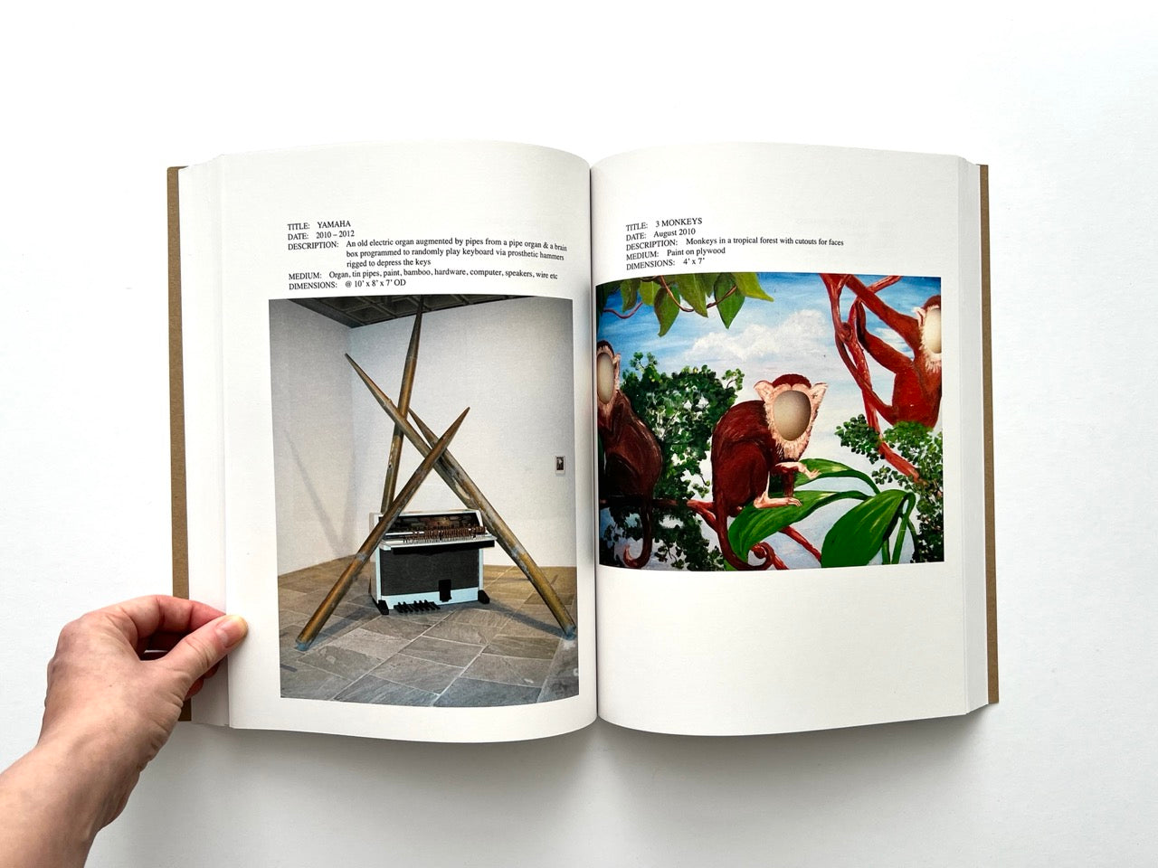 Lutz Bacher: Snow (2013), interior spread showing modified organ installation with crossed wooden poles and “3 Monkeys” painting of faceless primates in tropical foliage