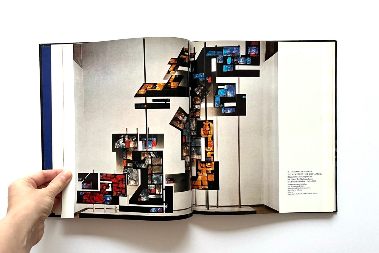 Open book - 'Moderne litauische Glasmalerei' - displaying a geometric stained glass design with abstract shapes.