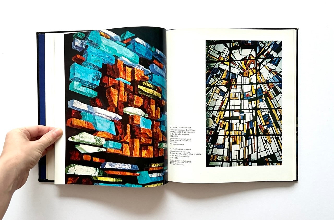 Open book - 'Moderne litauische Glasmalerei' - showing colorful abstract stained glass art.