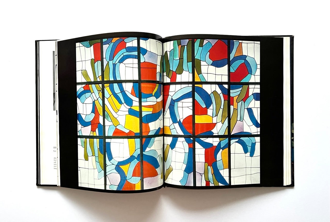 Open book with abstract stained glass design.