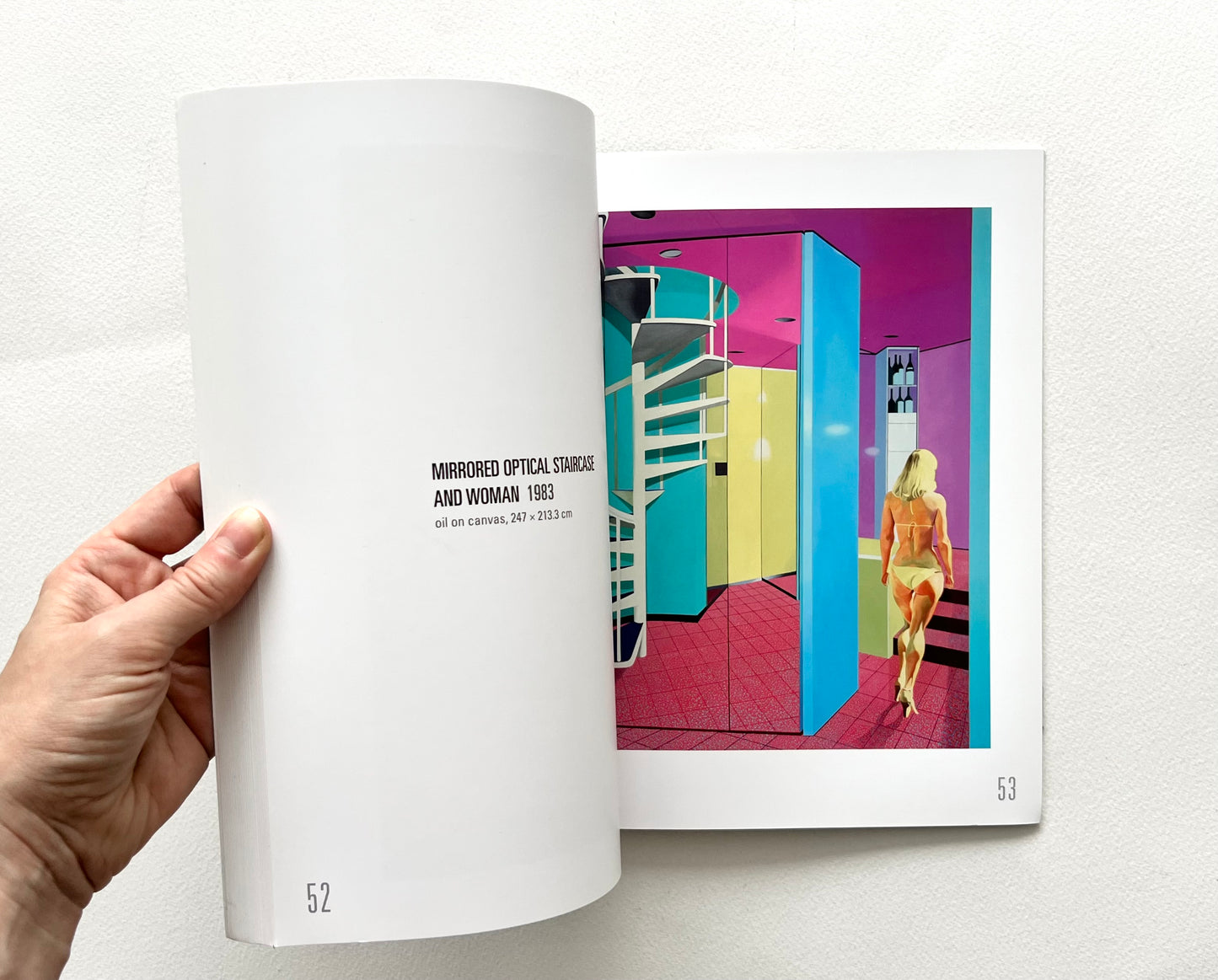An open 'Neil Stokoe: Paintings from the 60s on' book showing an artwork with a woman in bikini seen from the back, walking through a colorful interior featuring a spiral staircase. 