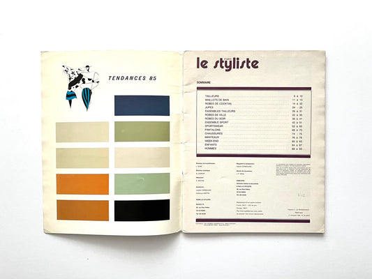 Interior spread from Paris Le Styliste No. 15 (1985): left page shows nine horizontal colour blocks labelled ‘Tendances 85’ with a small fashion illustration above; right page lists the issue’s contents in French with section page numbers, printed in purple on cream paper.