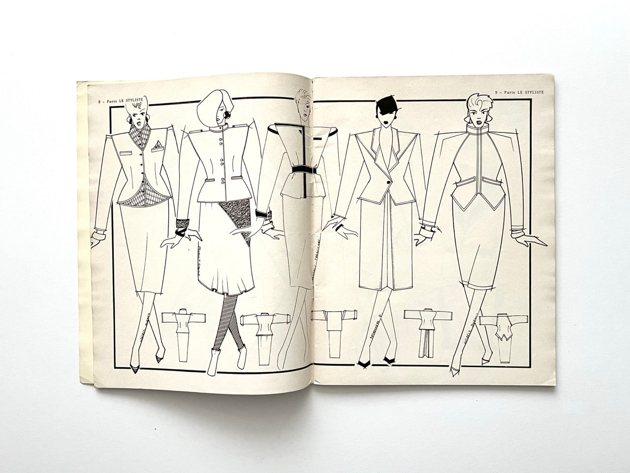 Illustrated spread from Paris Le Styliste No. 15 (1985) showing five women in sharply tailored 80s skirt suits with strong shoulders, peplum details, fitted waists and geometric paneling; smaller technical jacket drawings line the bottom.